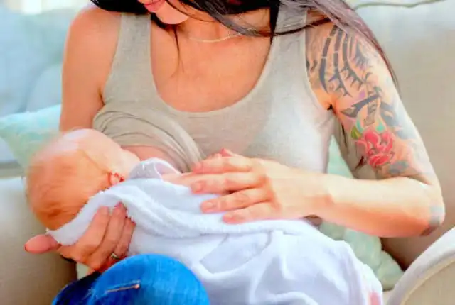 tattooed girl breastfeeding baby